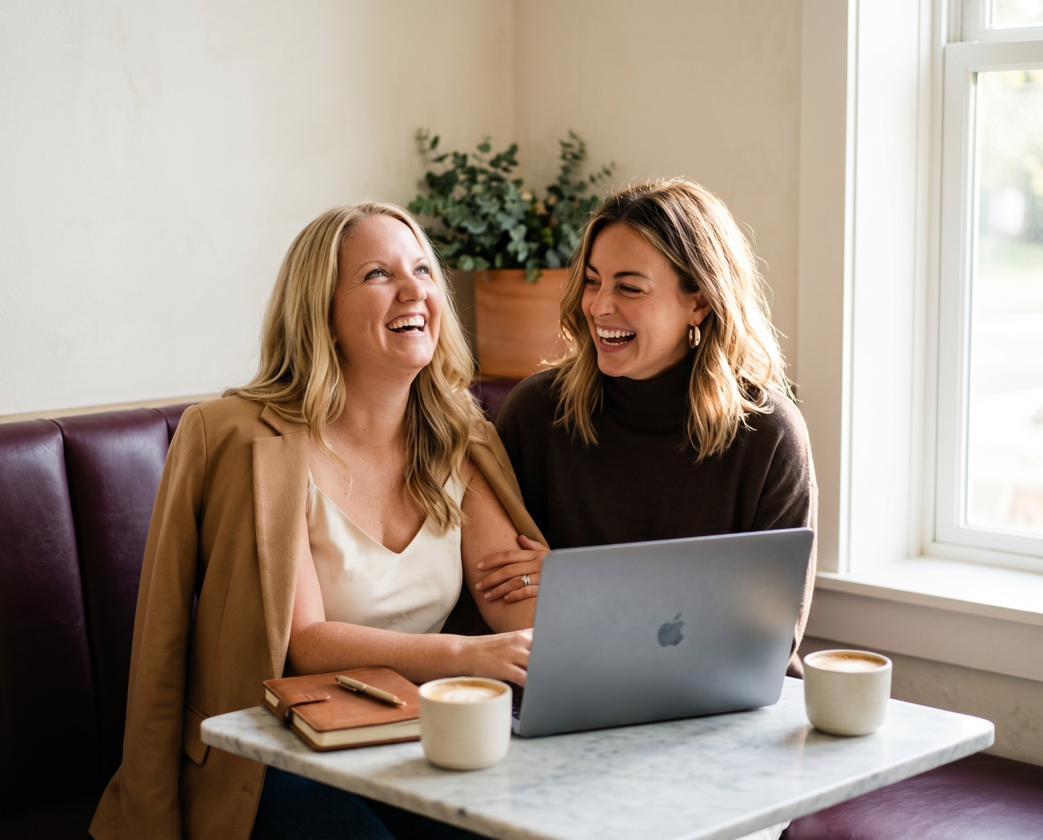 AtoB Edge founders Ashleigh and Beth working together over a laptop and coffee