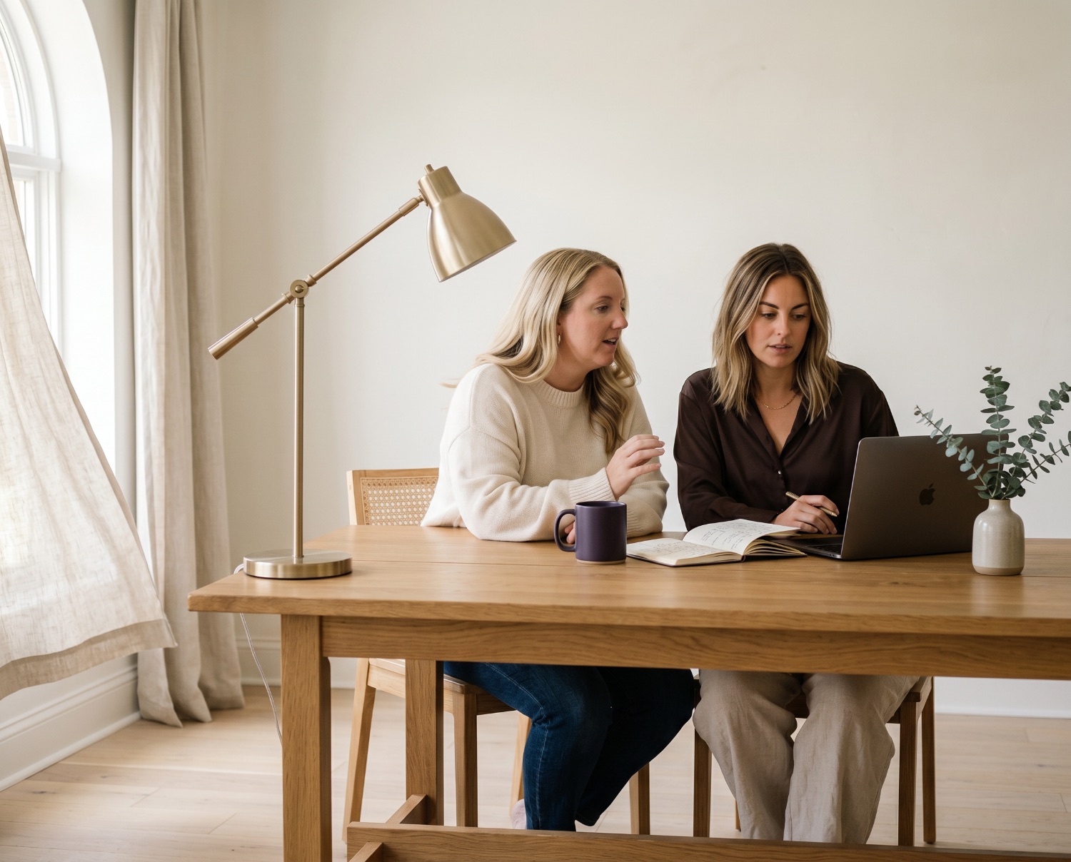 Ashleigh and Beth reviewing a marketing plan together at a sunlit table